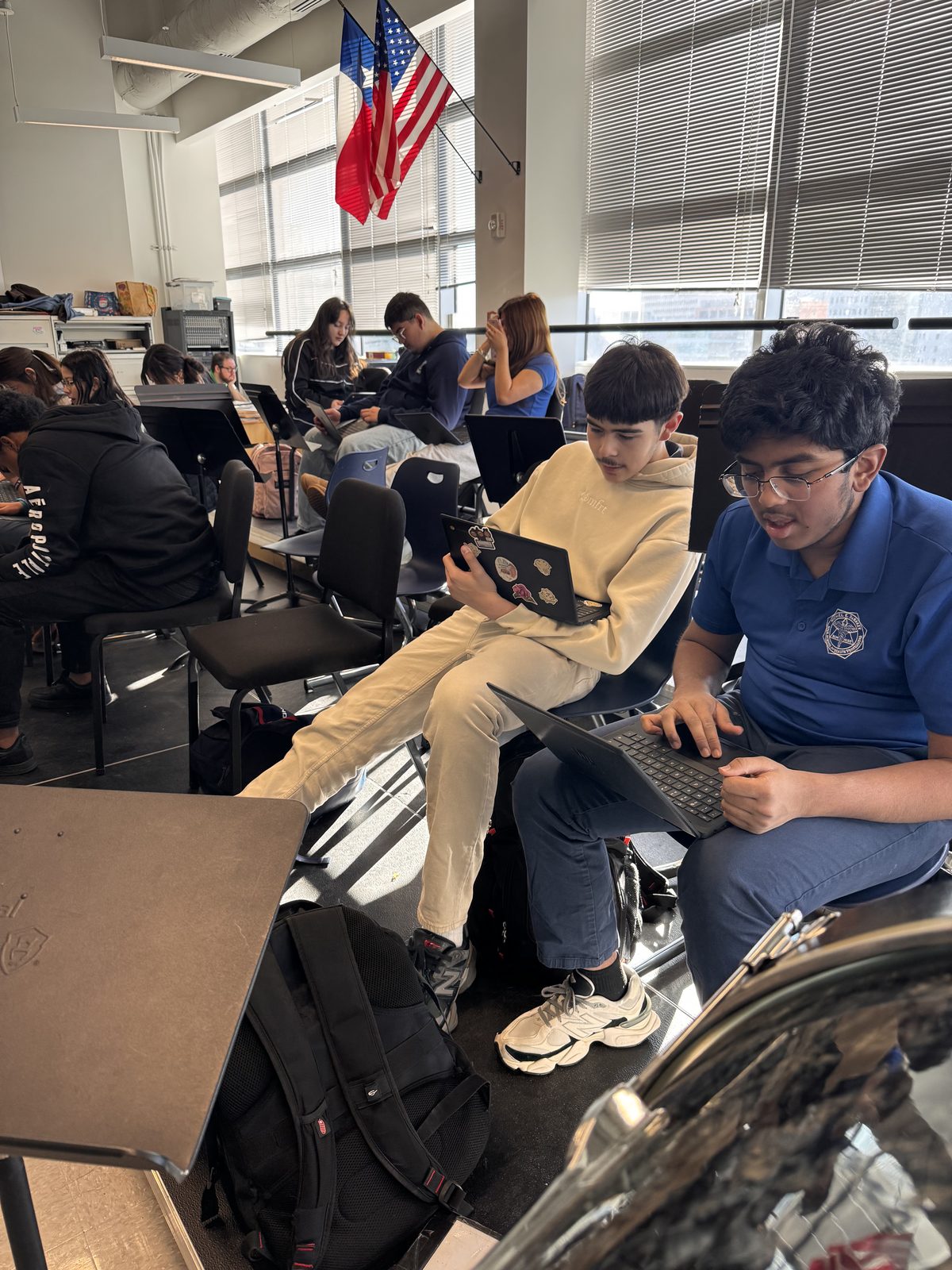 Students collaborating over a laptop in a school classroom during a Kinetic Vibez music program