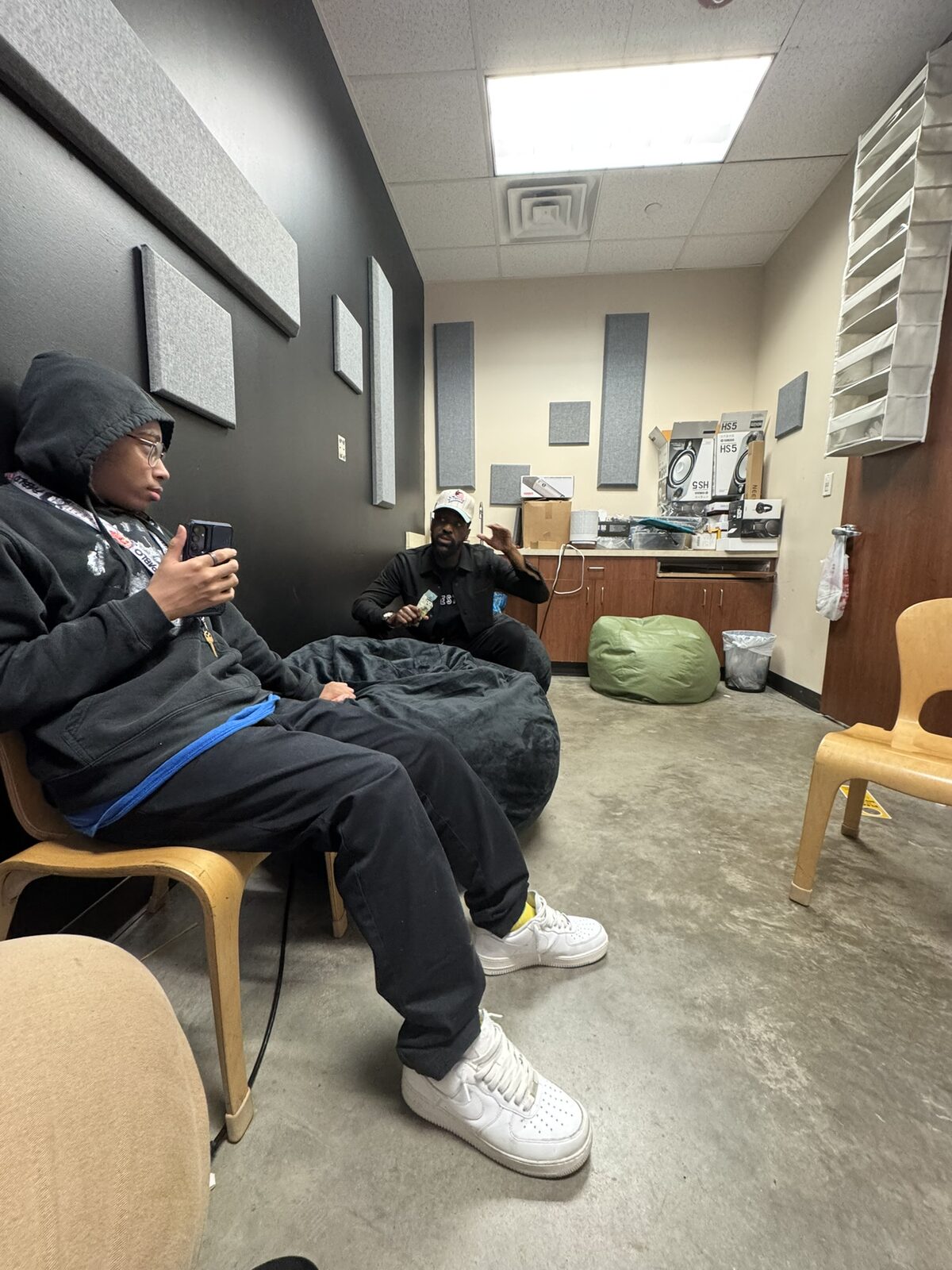 Kinetic Vibez instructor consulting with a student in an acoustic studio space — professional development and mentorship in action
